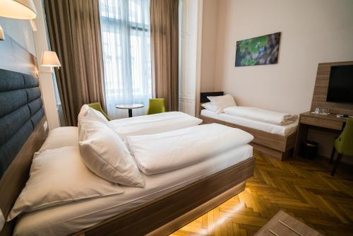 维也纳Hotel Marc Aurel - Newly refurbished的酒店客房设有两张床和电视。