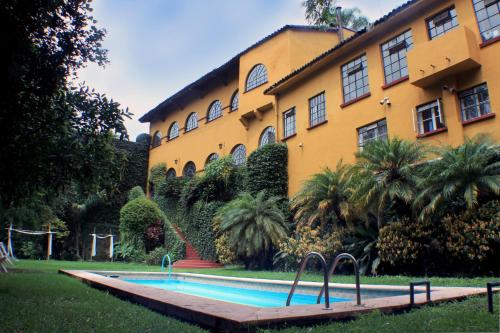 库埃纳瓦卡Casa Madero Rooms的大楼前的游泳池