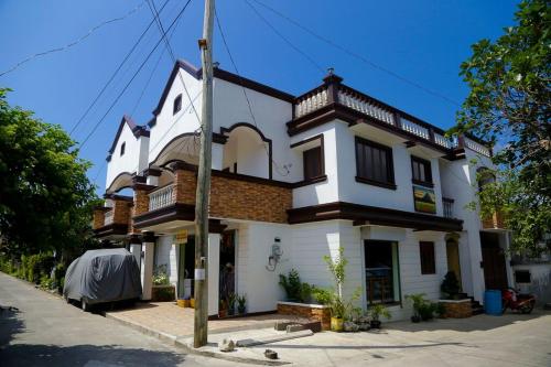 巴斯科Florabells Iraya Guest House - Batanes的街道上带阳台的大型白色房屋