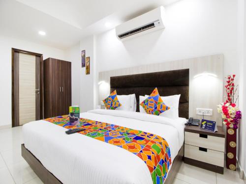 新德里Green Lotus Residency Dwarka的一间卧室配有一张大床和色彩缤纷的毯子