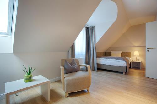 胡苏姆贝斯特韦斯特酒店 - 特奥多尔斯蒂姆店的阁楼卧室配有床和椅子