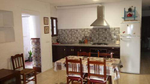 埃尔博斯克Casa El Patio (wifi, aire)的厨房配有桌椅和冰箱。