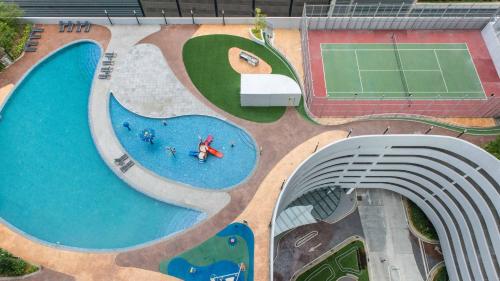 努沙再也Encorp Marina Suites By Iconic Bliss的享有带网球场的游泳池的顶部景致
