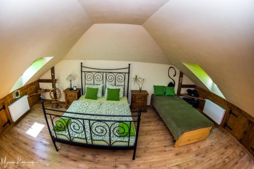 WojcieszówAgroturystyka Kapellanka - Kraina Wygasłych Wulkanów的阁楼卧室配有带绿色枕头的床