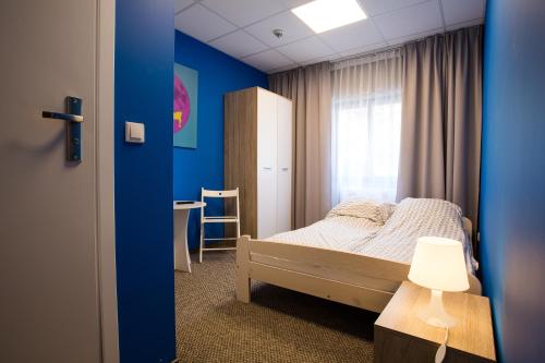 波兹南Moon Hostel Poznań的一间卧室设有一张床和蓝色的墙壁