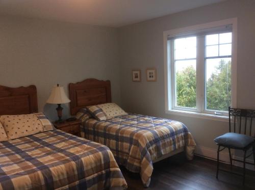 圣多纳特蒙卡尔姆Condo Lac Archambault 298的一间卧室设有两张床和窗户。