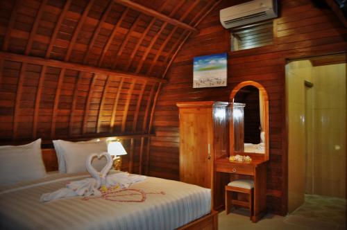 珀尼达岛Setilas Bungalows的一间卧室配有一张带天鹅的床