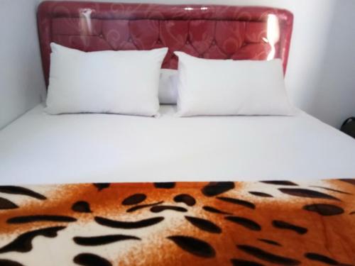 布罗莫Agung Safira Homestay的一张带两个枕头和老虎打印毯的床