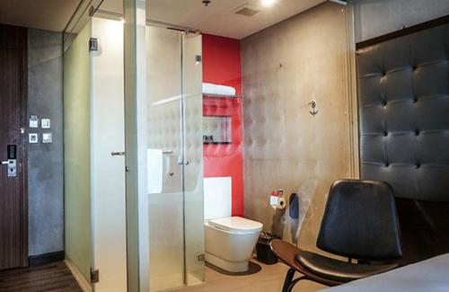 马尼拉The B Hotel Quezon City的一间带卫生间和椅子的浴室
