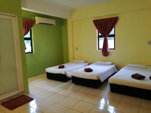 米里步行旅馆的带三张床的客房,设有绿色墙壁和窗户