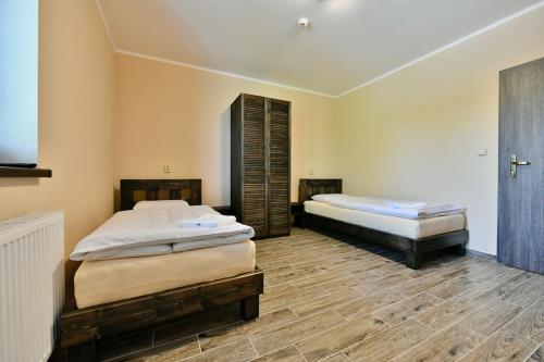 Horní TěrlickoWellness Hotel Fridrich的铺有木地板的客房内的两张床