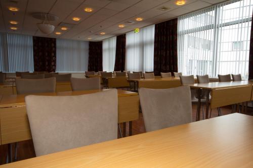 芬斯内斯芬斯内斯酒店的一间会议室,配有桌椅和窗户