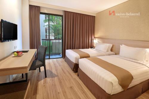 索龙索龙瑞雅酒店的酒店客房配有两张床和一张书桌