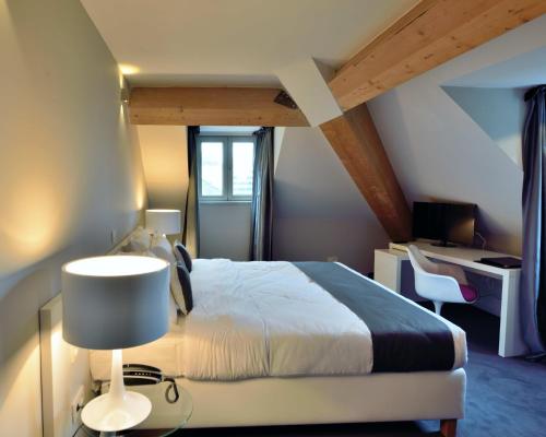 布鲁塞尔复古酒店的一间卧室配有一张床和一张带台灯的书桌