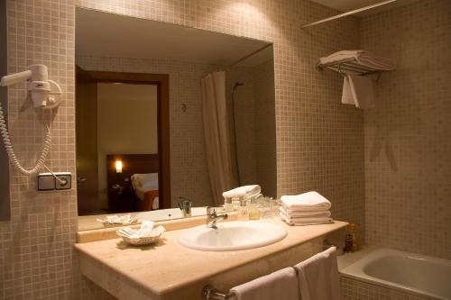图德拉托雷蒙雷阿尔酒店的浴室配有盥洗盆、镜子和浴缸