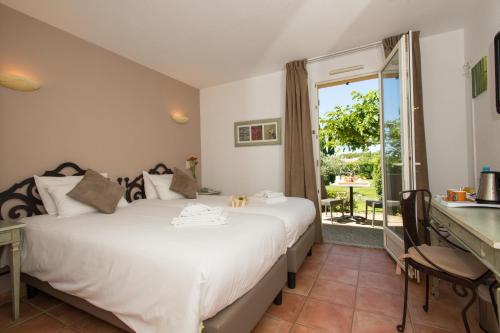 莫桑莱阿尔皮莱欧利亚贝斯特韦斯特酒店的一间卧室配有一张床、一张书桌和一个窗户。