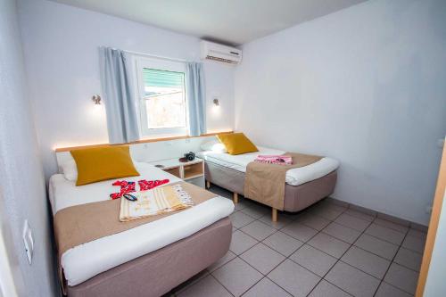 波多黎各特拉扎玛阳光套房塞瓦图尔酒店的小房间设有两张床和椅子