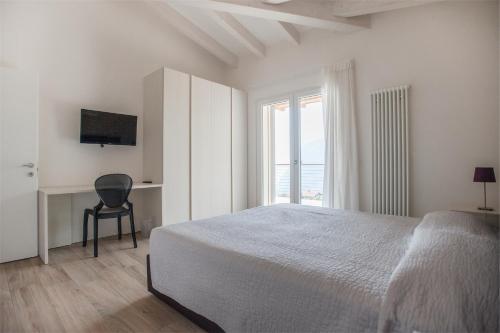 滕诺Terrazze sul Garda的白色的卧室设有床和窗户