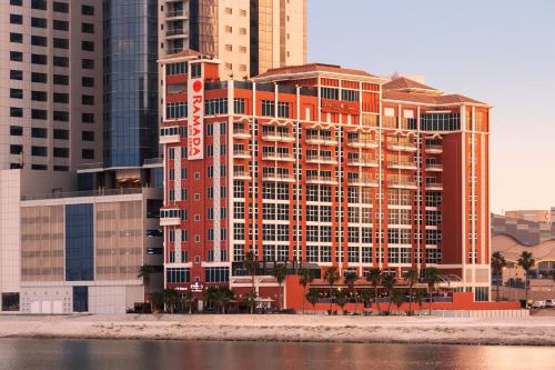 麦纳麦Ramada by Wyndham Manama City Centre的海滩上一座大型建筑,有高大的建筑