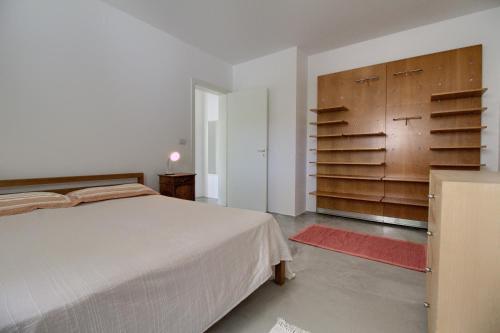 莱乌卡La Macchia的一间卧室配有一张大床和木制橱柜。