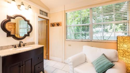 基韦斯特L'Habitation Guesthouse- Adult Exclusive的一间带沙发、水槽和镜子的浴室