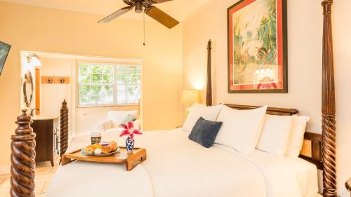 基韦斯特L'Habitation Guesthouse- Adult Exclusive的卧室配有白色的床和桌子