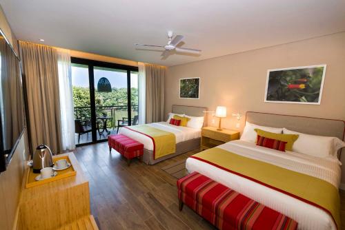 伊瓜苏港伊瓜苏丛林别墅酒店的酒店客房设有两张床和一个阳台。