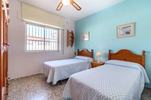 Churriana de la VegaChalet acogedor con piscina muy cerca de Granada的配有两张床铺的蓝色墙壁和窗户