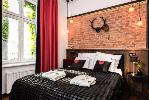克拉科夫Wooden Horse - New Apartment - Old Town的一间卧室设有砖墙和一张带枕头的床