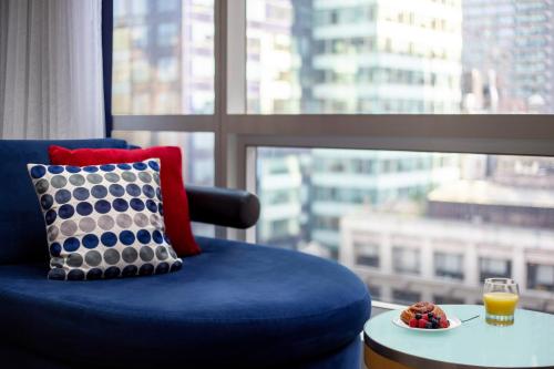 纽约千禧纽约时代广场酒店的靠窗边桌子上摆放着一碗水果的蓝色椅子