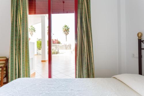 桑卢卡尔-德巴拉梅达Bonito apartamento en campo de golf con piscina的一间卧室配有一张床,享有庭院的景色
