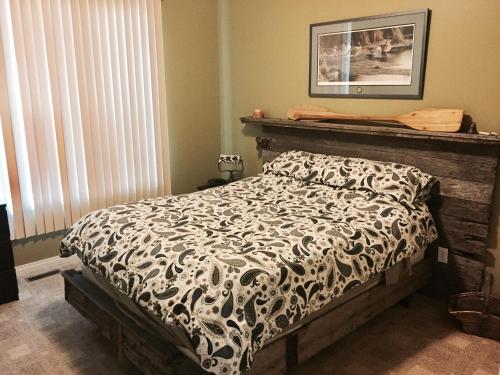 Grand BeachPebble Springs BnB的一间卧室配有一张带黑白色棉被的床