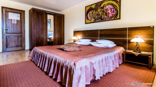 雷京Valea Regilor Reghin的一间卧室配有一张带粉色毯子的大床