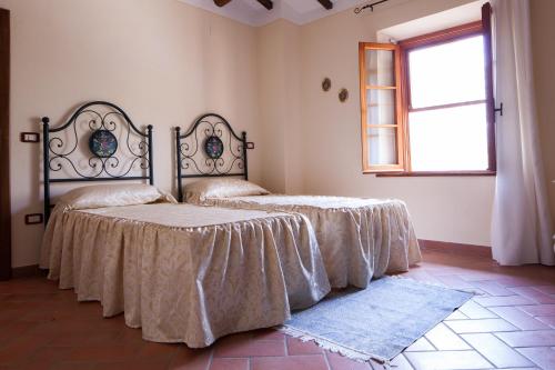 托里塔迪谢纳Podere Villa Rosa的一间卧室设有两张床和窗户。