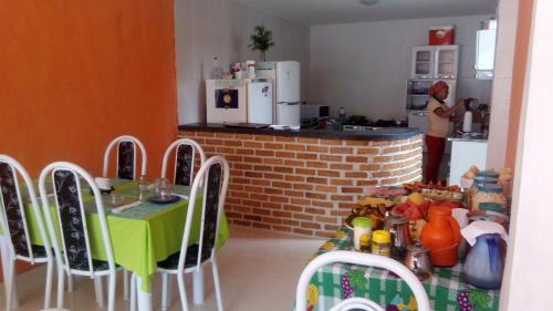 伦索伊斯Pousada Casa da Neuzita的一位女性在厨房里,在厨房里,有桌椅