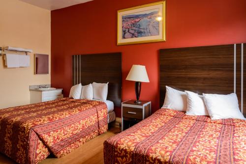 旧金山Europa Hotel的红色墙壁的酒店客房内的两张床
