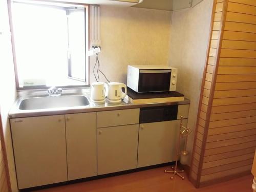 桑名市Minpaku Nagashima room1 / Vacation STAY 1028的厨房配有水槽和微波炉