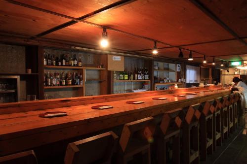 白马村加拿大悟龙村酒店的餐厅内带长木柜台的酒吧
