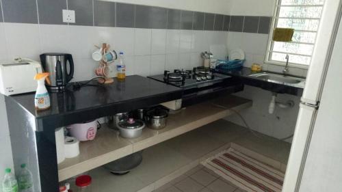 班吉Affordable Stay @ Rue’s Villa Tropika Apartment, UKM Bangi的小厨房配有炉灶和水槽