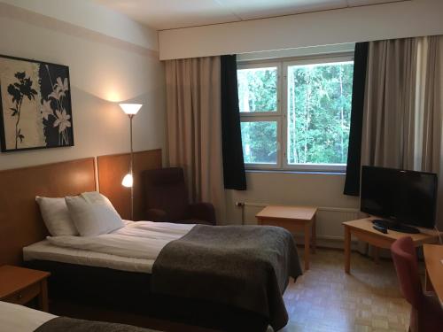 塞伊奈约基弗格尼尼芬兰酒店的酒店客房,配有床和电视