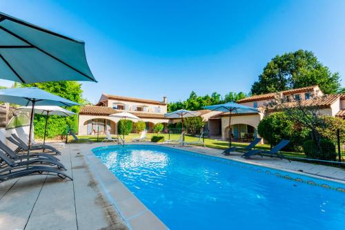 格雷乌莱班塞维尼别墅酒店的房屋旁的游泳池配有椅子和遮阳伞