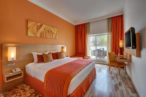 迪拜阿尔瓦斯尔奥酷瑞商务酒店 的酒店客房设有一张大床和一台电视。