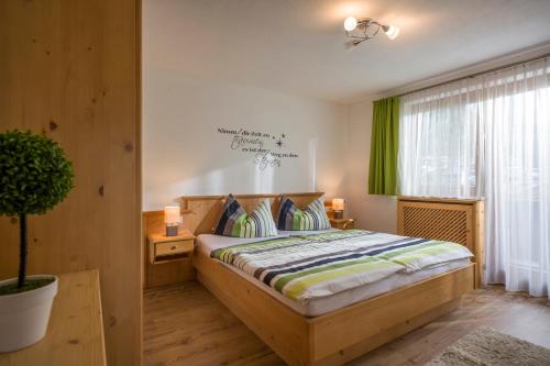 弗林肯贝格伯格霍夫盖斯勒公寓式酒店的一间卧室配有一张带绿帘的木床