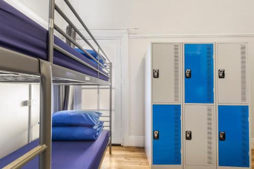 悉尼悉尼背包客酒店的客房设有2张双层床和蓝色枕头。