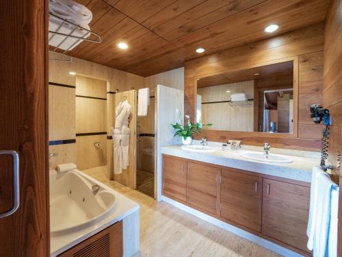塞瓦Montanyà的浴室配有2个盥洗盆、浴缸和大镜子