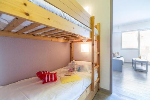 圣马克西姆皮埃尔法国梧桐假日酒店的一间卧室配有两张双层床。