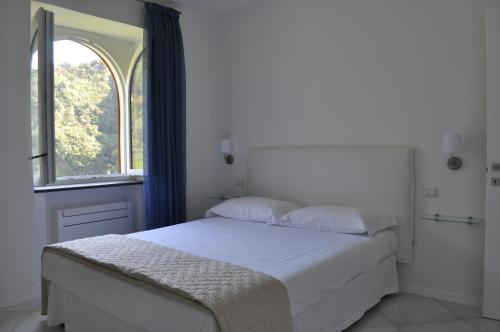 阿马尔菲Via Paradiso的白色的卧室设有床和窗户