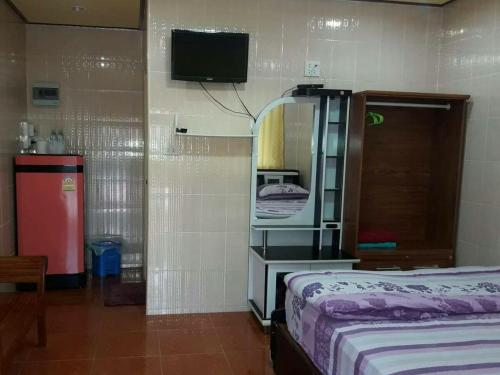 亚兰Muean Fhan Resort Aranyaprathet的一间卧室配有一张床、镜子和电视