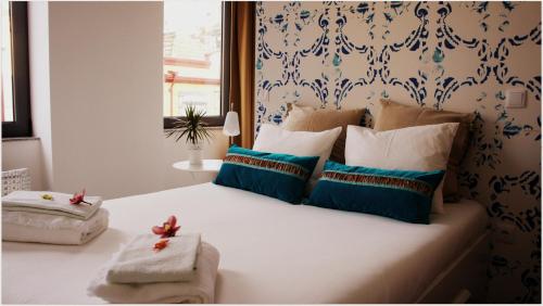 加亚新城盖亚波尔图旅馆的一间卧室配有一张带蓝色和白色枕头的床