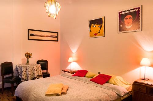 利马Casa Nuestra Peru的卧室配有一张床,墙上挂有两张照片